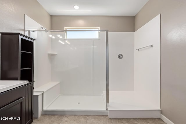 bathroom featuring walk in shower and vanity