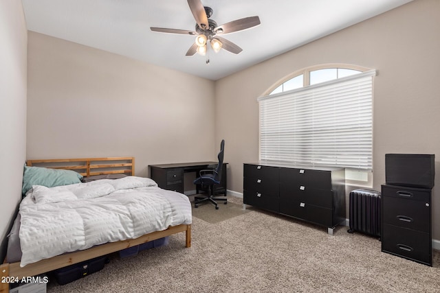 bedroom with ceiling fan, light colored carpet, and radiator