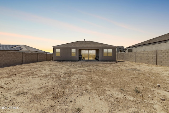 view of back house at dusk