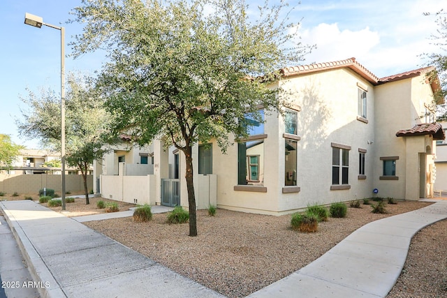 14870 W Encanto Blvd Unit 1038, Goodyear, AZ 85395 - view of front of house with a tiled roof, stucco siding, and a gate