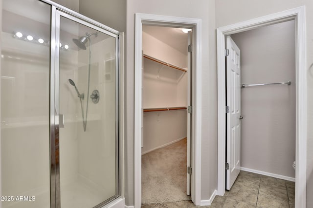 14870 W Encanto Blvd Unit 1038, Goodyear, AZ 85395 - bathroom featuring a stall shower and a walk in closet
