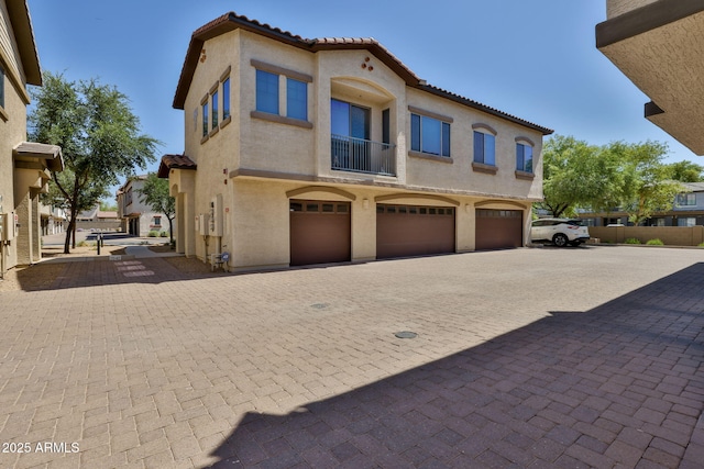 14870 W Encanto Blvd Unit 1038, Goodyear, AZ 85395 - view of front of home with a tiled roof, an attached garage, stucco siding, and a balcony