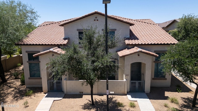 14870 W Encanto Blvd Unit 1038, Goodyear, AZ 85395 - mediterranean / spanish house featuring a tiled roof, a gate, a fenced front yard, and stucco siding