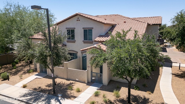 14870 W Encanto Blvd Unit 1038, Goodyear, AZ 85395 - mediterranean / spanish home featuring a tile roof, stucco siding, a fenced front yard, and a gate