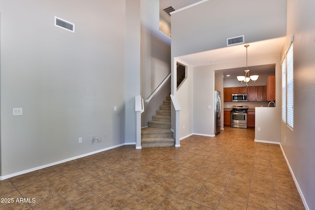 14870 W Encanto Blvd Unit 1038, Goodyear, AZ 85395 - unfurnished living room featuring a chandelier, stairs, and a towering ceiling