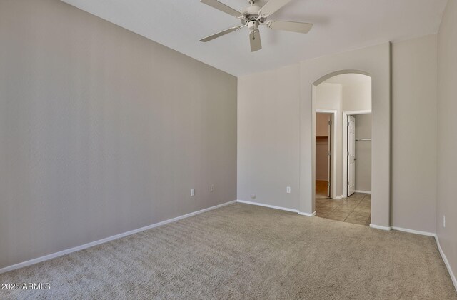 14870 W Encanto Blvd Unit 1038, Goodyear, AZ 85395 - empty room featuring arched walkways, carpet, and ceiling fan