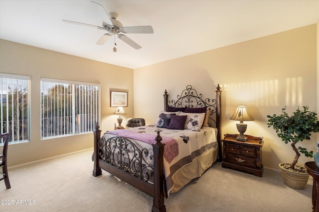 bedroom featuring a ceiling fan, light colored carpet, and baseboards