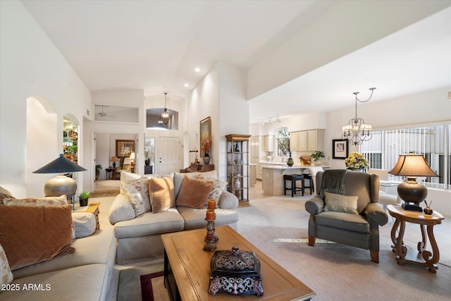 living area featuring carpet, a notable chandelier, and a high ceiling