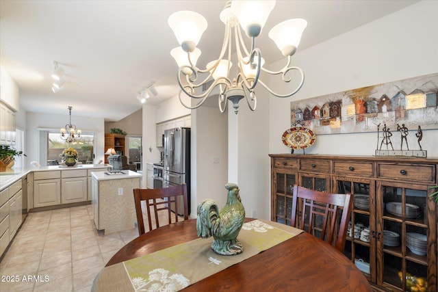 dining area featuring light tile patterned floors, rail lighting, and a notable chandelier