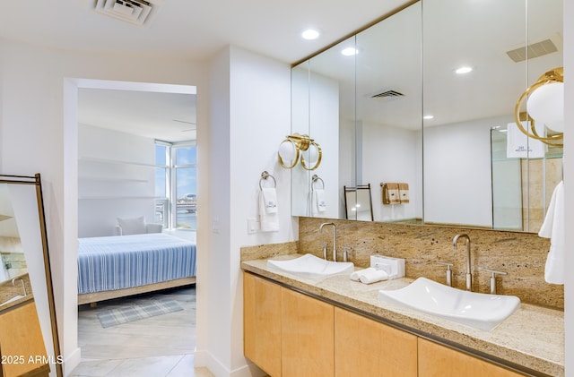 bathroom featuring tile patterned floors, vanity, and tasteful backsplash