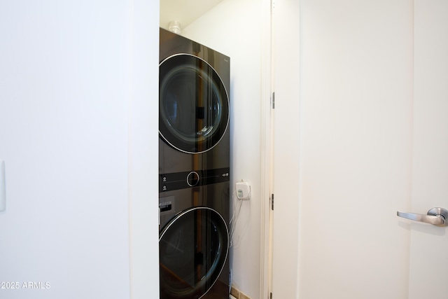 clothes washing area featuring stacked washing maching and dryer