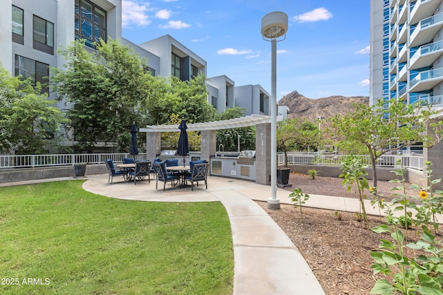 view of home's community featuring a mountain view, a pergola, a patio area, and a lawn