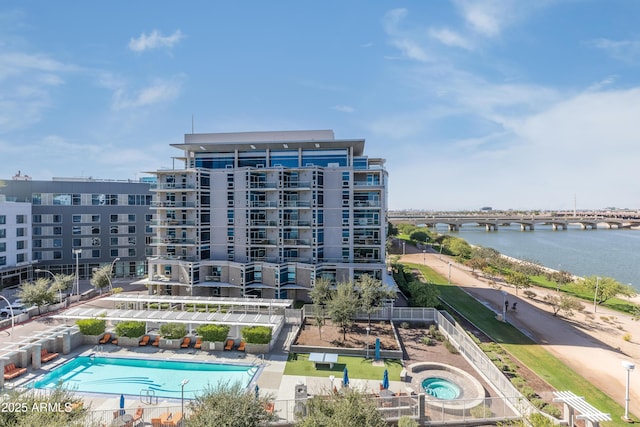 view of property with a community pool and a water view