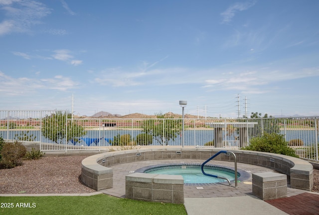 view of swimming pool with a water view and an in ground hot tub