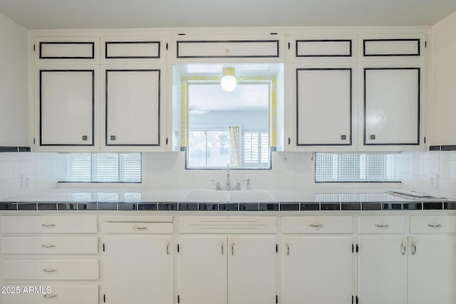 1945 E Solano Dr, Phoenix, AZ 85016 - kitchen with white cabinets, decorative backsplash, and tile counters