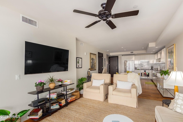 living room featuring ceiling fan and hardwood / wood-style floors