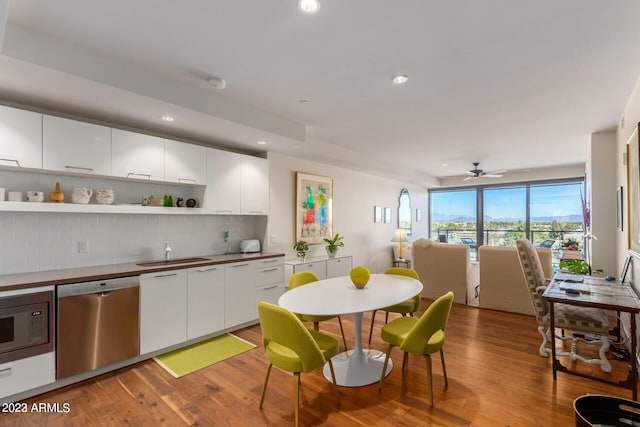 kitchen featuring built in microwave, white cabinets, dishwasher, and tasteful backsplash