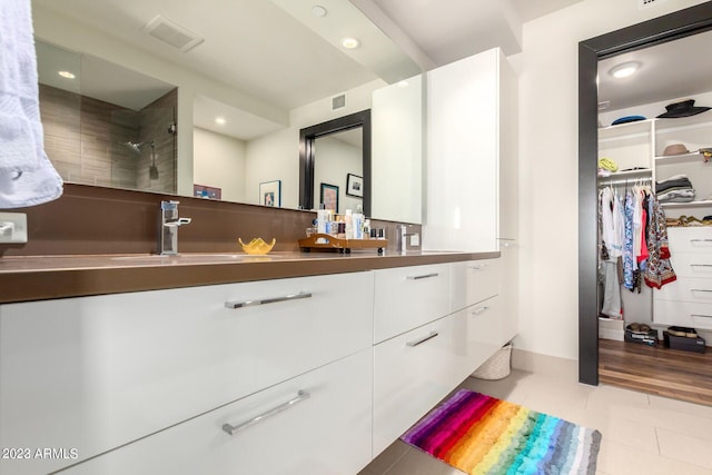 bathroom with vanity, tile patterned floors, and a tile shower