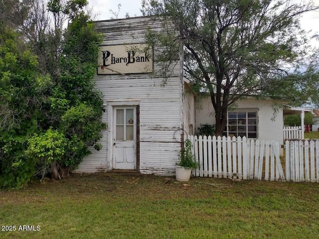 rear view of property featuring a lawn