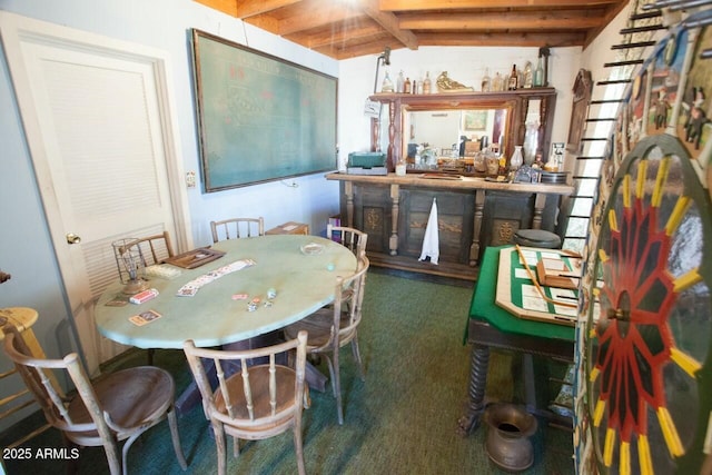 carpeted dining area featuring indoor bar and vaulted ceiling with beams