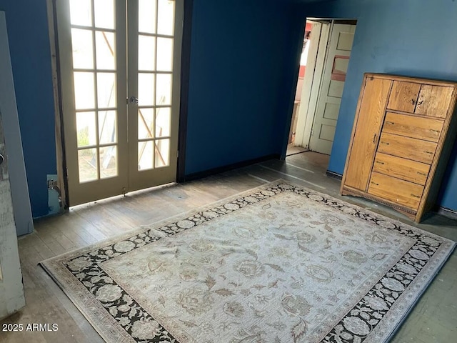 empty room with french doors and hardwood / wood-style flooring