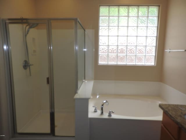 full bathroom featuring a wealth of natural light, a bath, and a stall shower