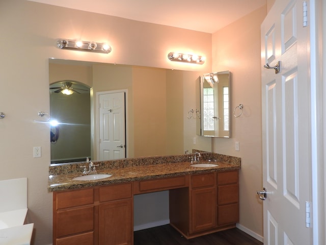 bathroom featuring double vanity, a ceiling fan, and a sink