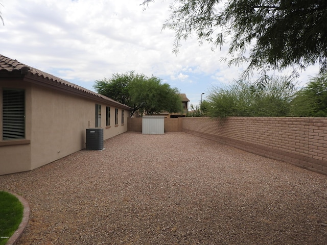 view of yard with a patio, central AC unit, and a fenced backyard