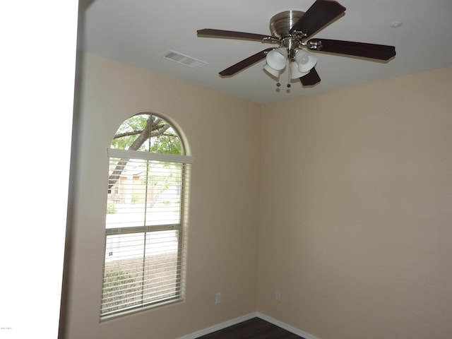 unfurnished room with ceiling fan, visible vents, and baseboards