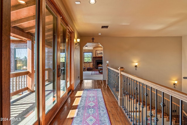 hallway with hardwood / wood-style floors and beam ceiling