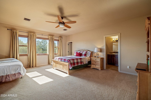 carpeted bedroom featuring ceiling fan and ensuite bath