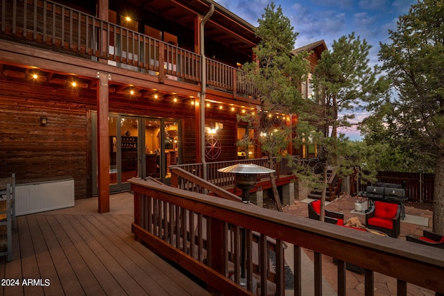 deck at dusk featuring a grill