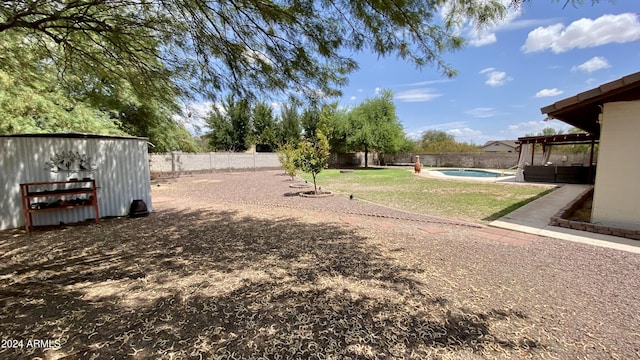 view of yard with a fenced in pool and a storage shed