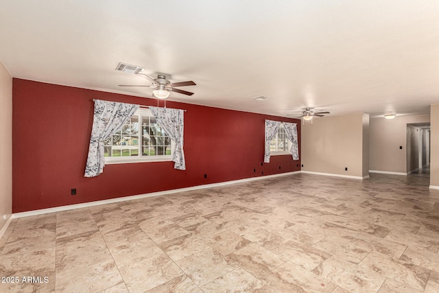 empty room with a ceiling fan, visible vents, and baseboards