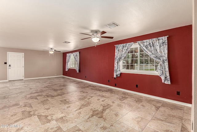 unfurnished room with visible vents, baseboards, and ceiling fan