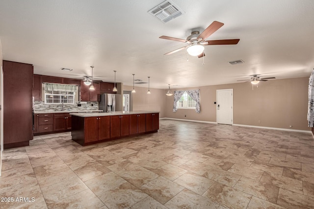 kitchen with visible vents, light countertops, open floor plan, and stainless steel fridge with ice dispenser