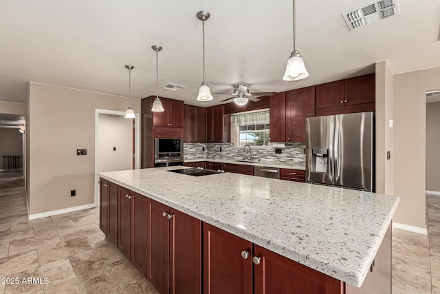 kitchen featuring visible vents, a center island, decorative backsplash, stainless steel appliances, and a sink