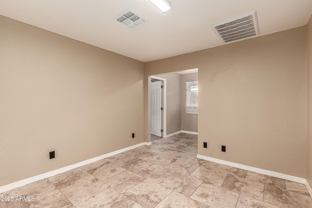 spare room with baseboards and visible vents