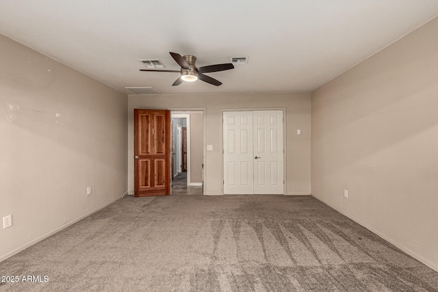 unfurnished bedroom featuring visible vents, carpet floors, a closet, and ceiling fan