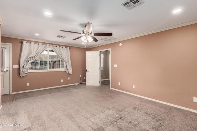 spare room with visible vents, carpet floors, and ornamental molding