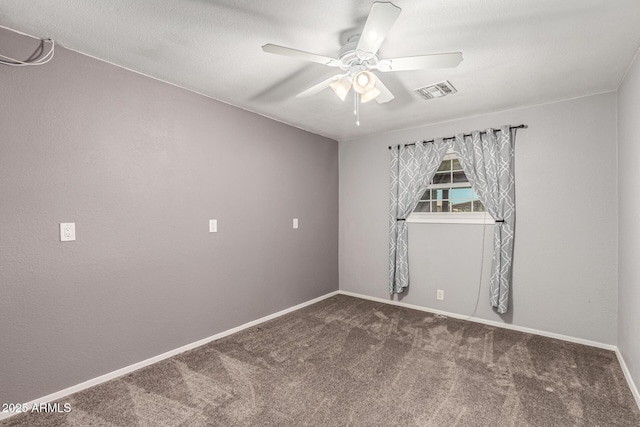 carpeted spare room featuring a ceiling fan, visible vents, and baseboards