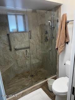 bathroom with toilet and an enclosed shower