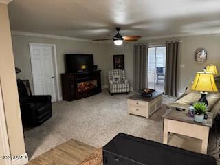 living room featuring carpet flooring, ceiling fan, and crown molding