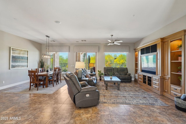 living room featuring a healthy amount of sunlight, ceiling fan, and baseboards