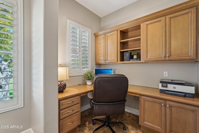 home office with built in desk and baseboards