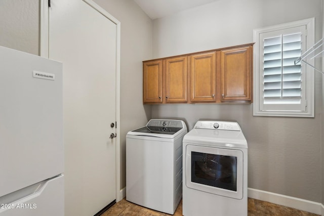 laundry area featuring baseboards, cabinet space, and washing machine and dryer