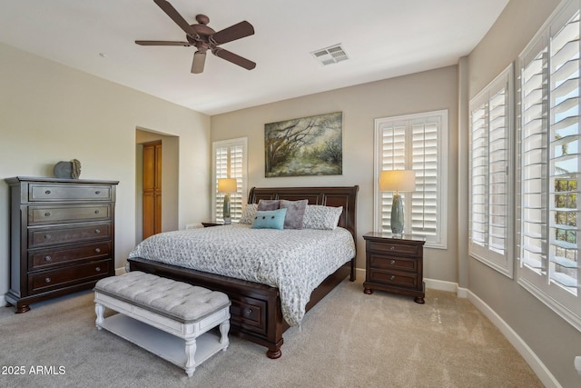 bedroom featuring light carpet, baseboards, multiple windows, and visible vents