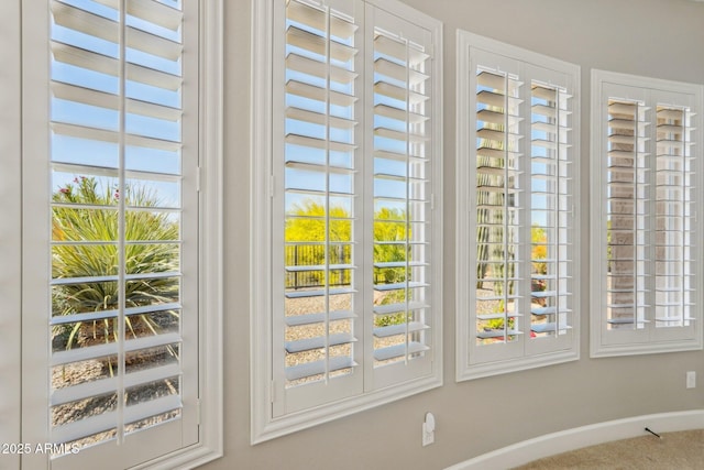 doorway to outside featuring a healthy amount of sunlight, carpet flooring, and baseboards