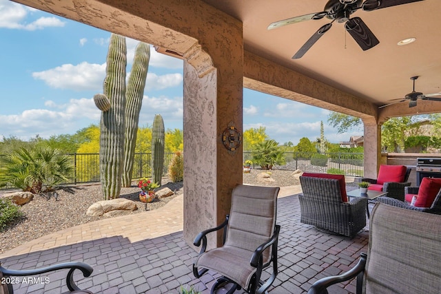view of patio with grilling area, fence, and a ceiling fan