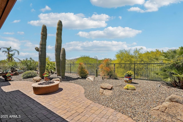 view of patio with an outdoor fire pit and fence